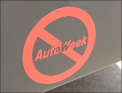 A photo of a bumper sticker that protests Auto Week magazine. 